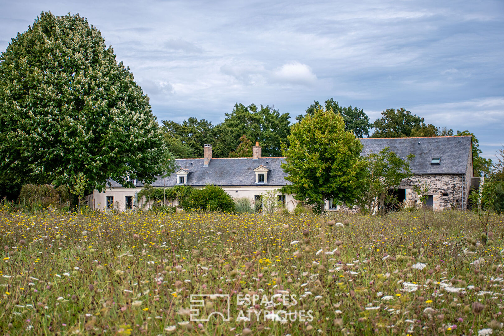 Renovated farmhouse in a green setting.