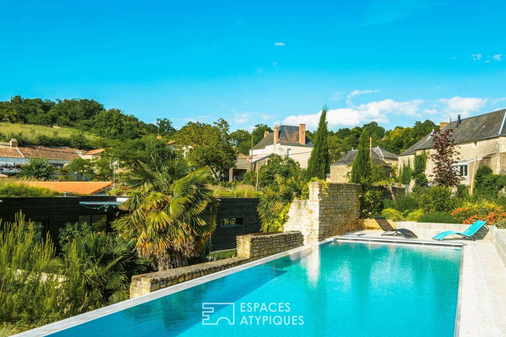 Maison d’architecte au toit plat végétalisé avec piscine à débordement