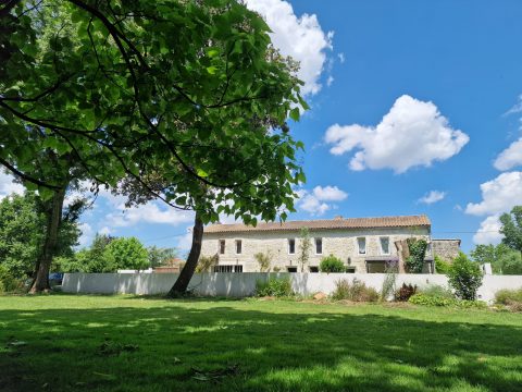 Family Charentaise in its green setting and its outbuilding