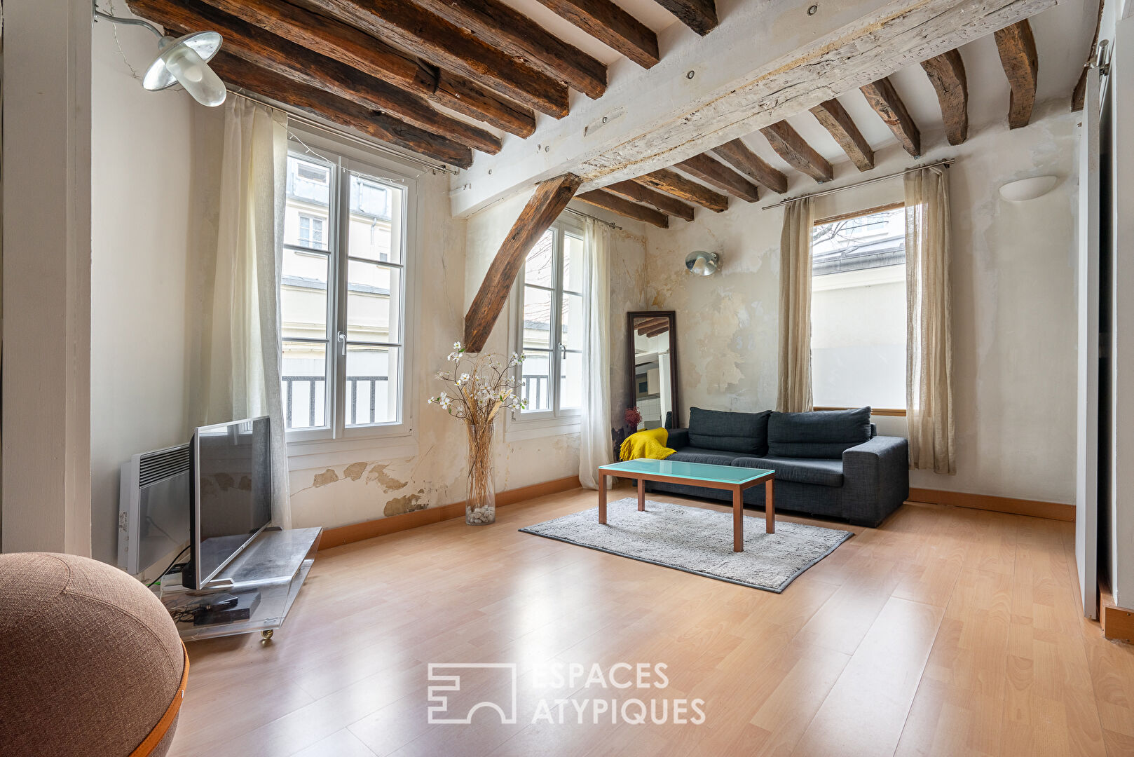 Apartment with exposed beams on paved courtyard