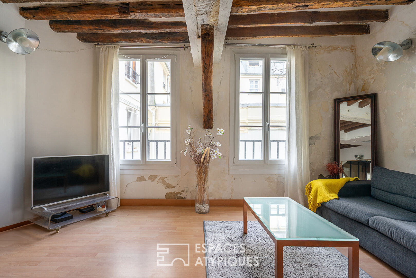 Apartment with exposed beams on paved courtyard