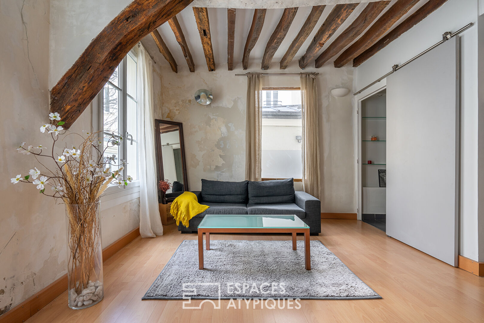 Apartment with exposed beams on paved courtyard