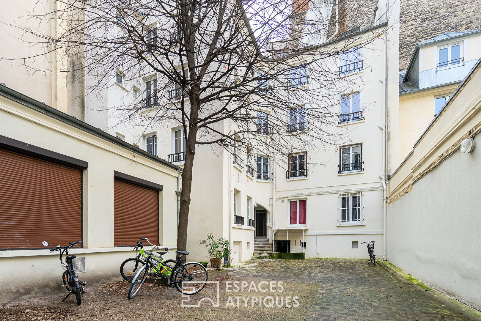 Apartment with exposed beams on paved courtyard