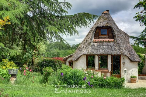 Maison en toit de chaume et ses espaces verts