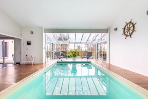 Maison d’architecte avec piscine intérieure tournée vers la forêt