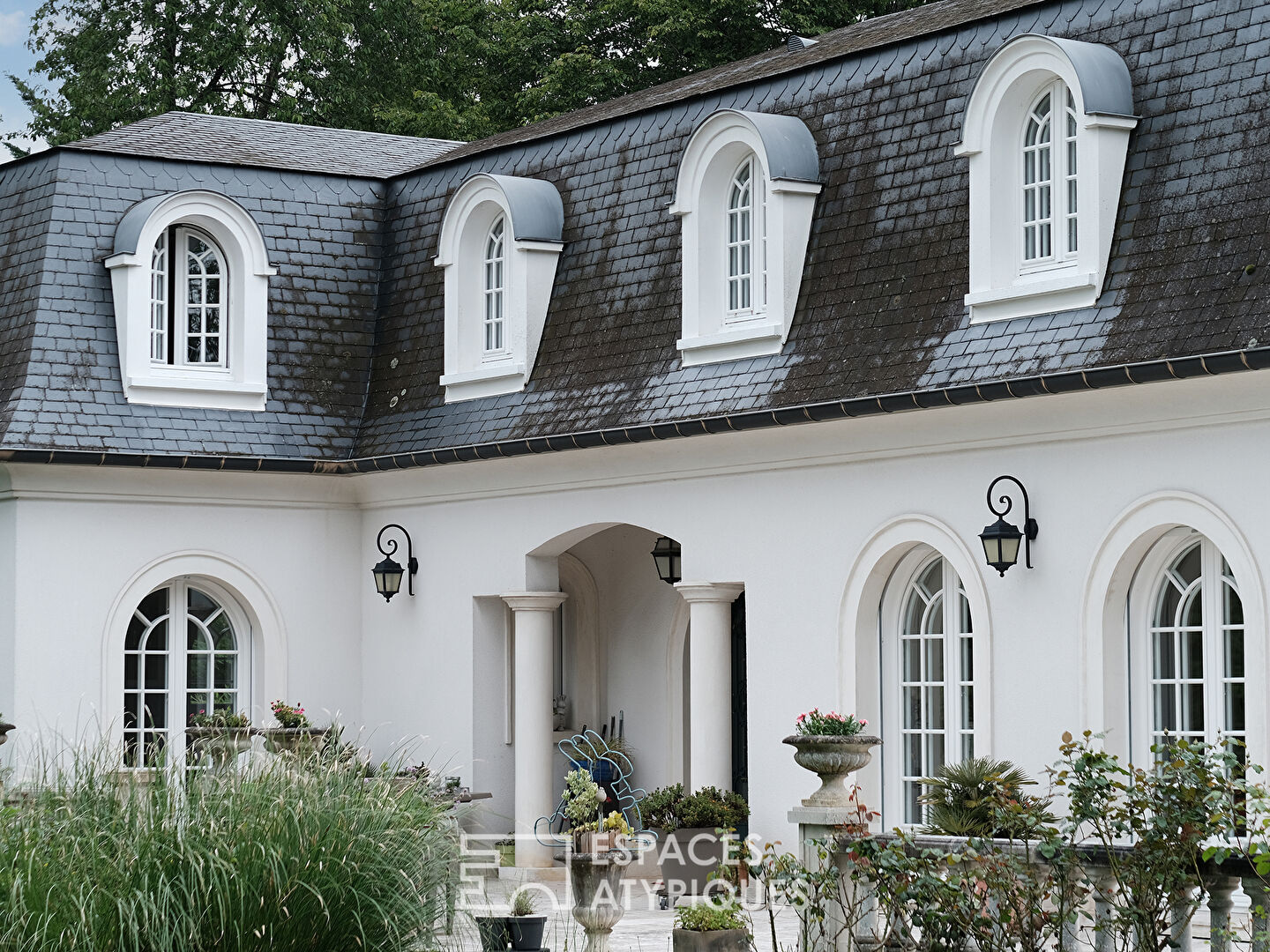 La maison spacieuse et son jardin avec piscine.