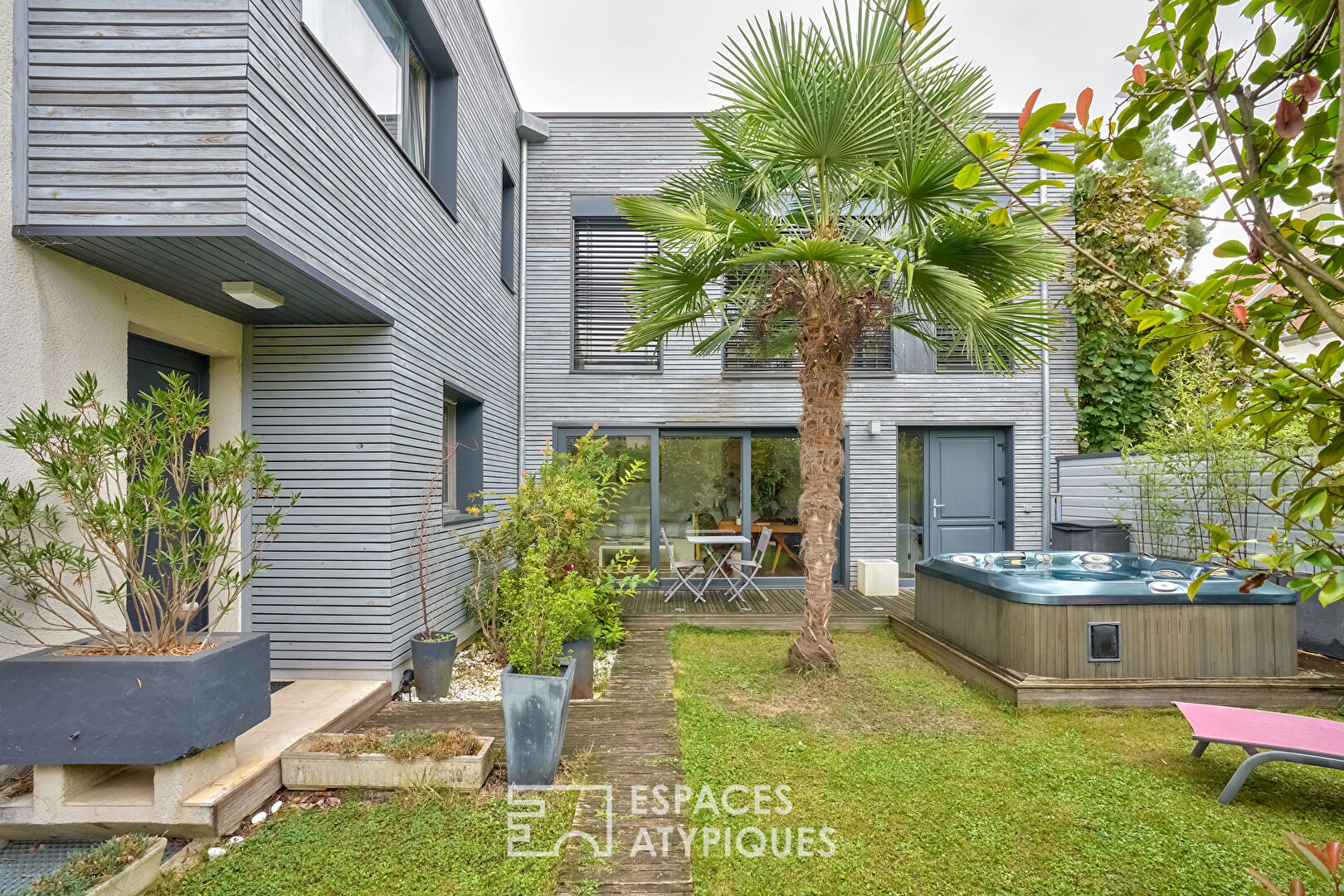 Maison contemporaine avec extension, trois terrasses, jardin et patio suspendu.