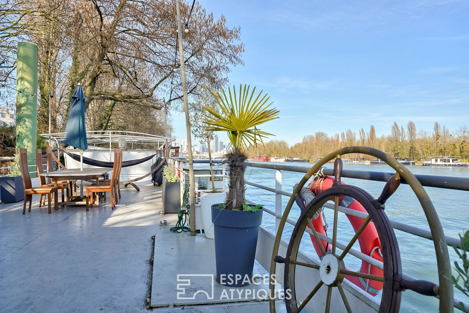 Péniche avec terrasse les pieds dans l’eau.