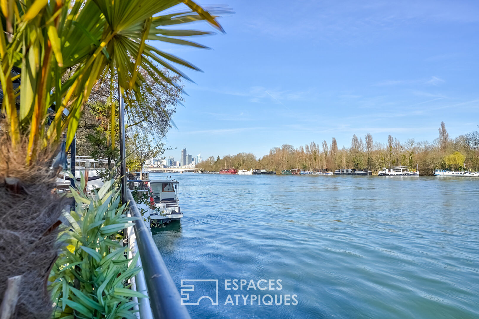 Péniche avec terrasse les pieds dans l’eau.